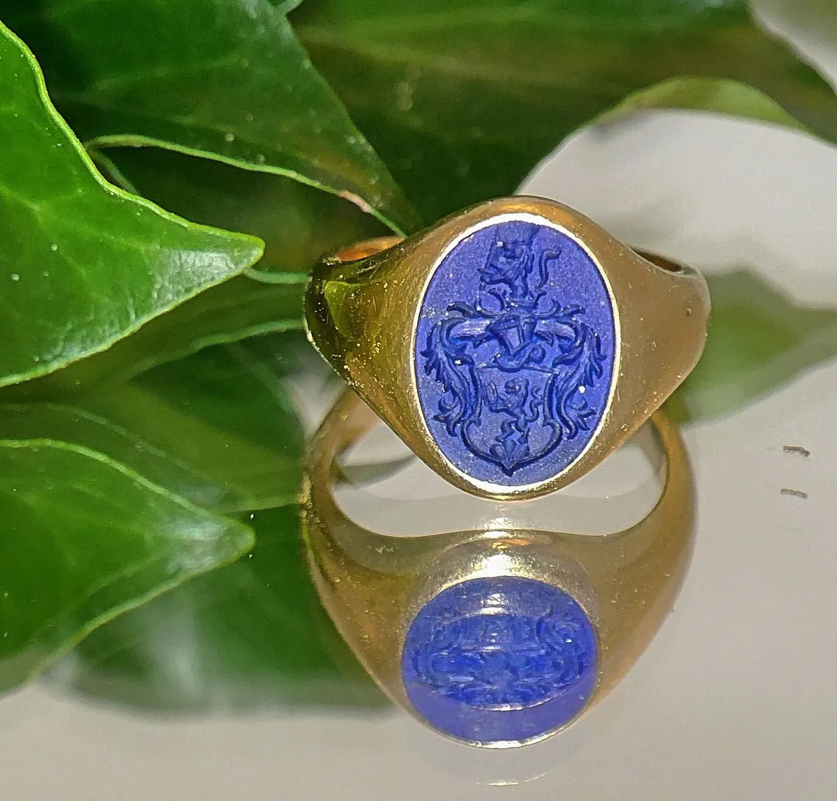 A gold signet ring engraved with a coat of arms, an old way of marking a letter as genuinely from you, as BIMI does for email.