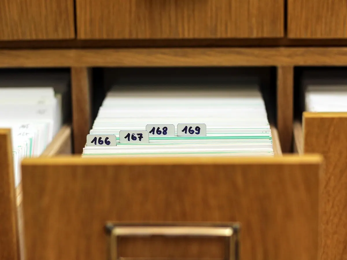 An open wooden card-index drawer with numbered tabs, 166 to 169, a physical version of the numbered records a server keeps for every file.