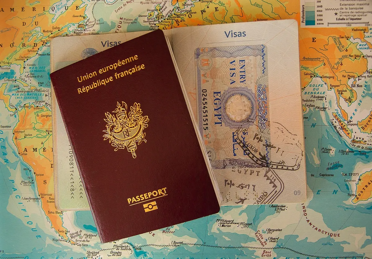 A passport resting on an open page of visa stamps, a paper version of what an SSL certificate does for a website's identity.