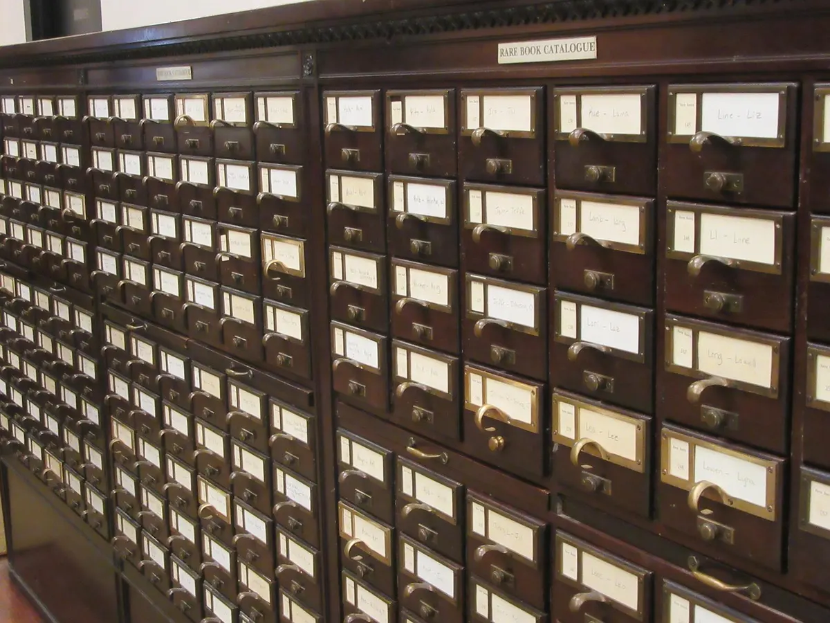 Rows of wooden card catalogue drawers in a library, an old-fashioned directory like the listings that make up local citations.