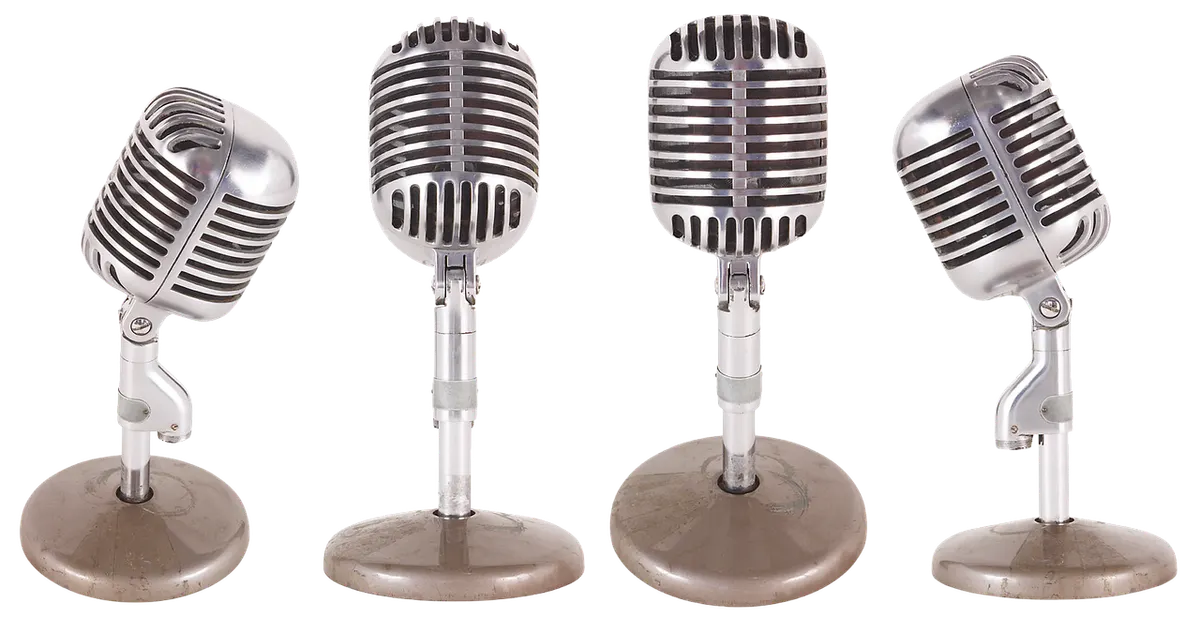 Four chrome vintage microphones on stands, each tilted at a different angle, like one voice adjusting its tone for different situations.
