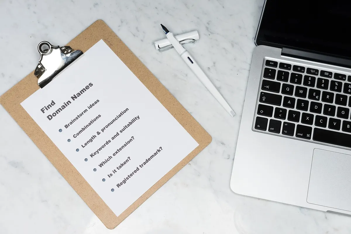 Clipboard holding a printed checklist beside a laptop, like the list of approved senders an SPF record keeps