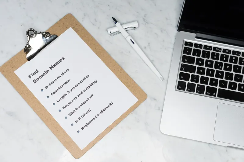 Clipboard holding a printed checklist beside a laptop, like the list of approved senders an SPF record keeps